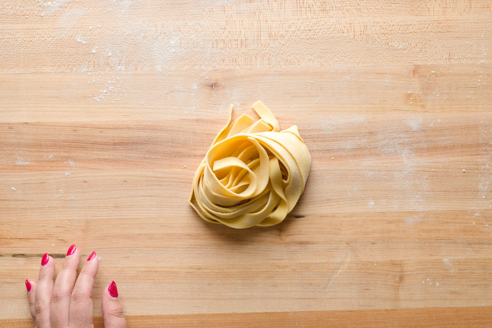 2 ingredient homemade pasta pappardelle nest on a wooden kitchen board