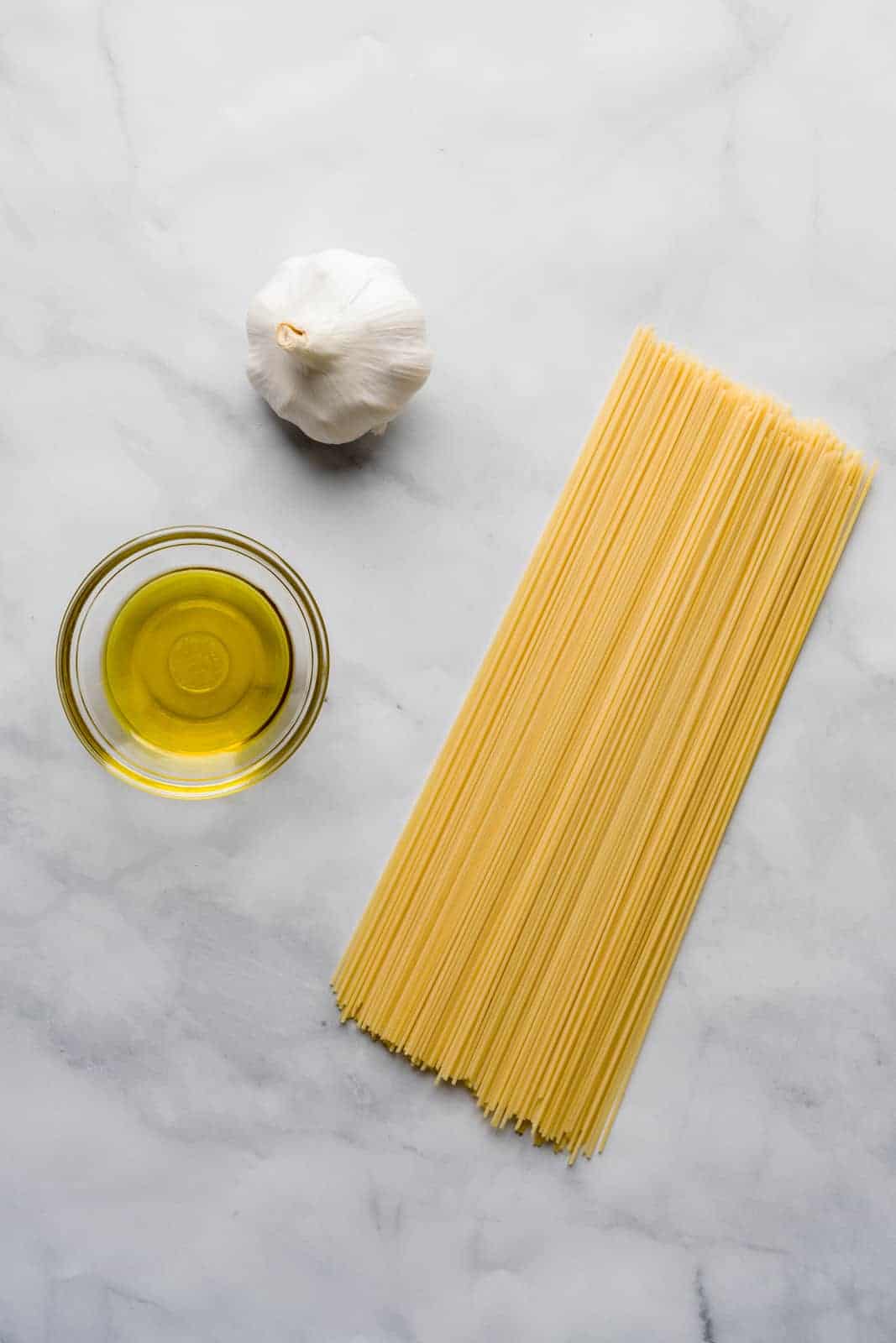 Ingredients for aglio e olio pasta - garlic, extra virgin olive oil and spaghetti.