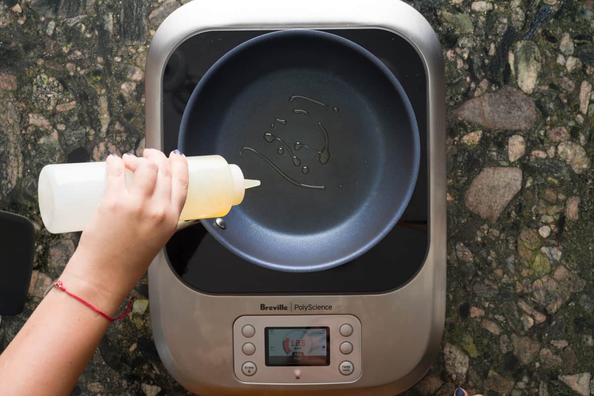 Pouring oil in a pan in preparation for the crepe batter.