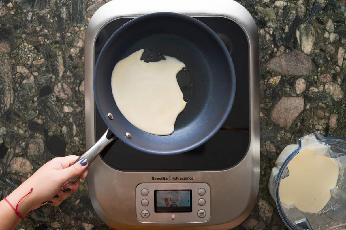 Swirling crepe batter in greased, heated pan.