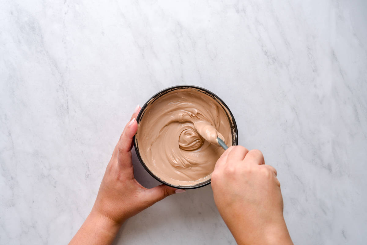 Mixing Nutella and Greek yogurt in a bowl for dirt cups.