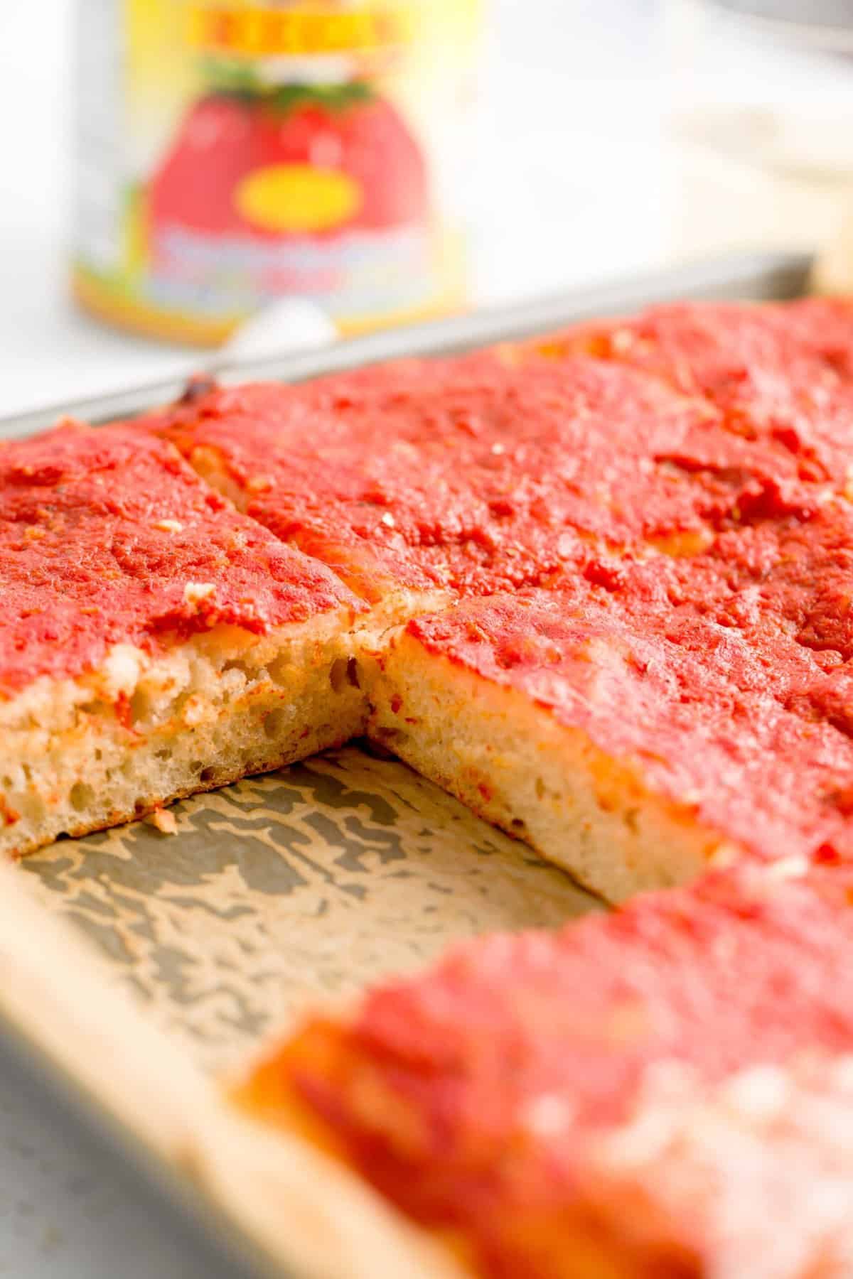 A side view of an empty spot where a slice of sheet pan pizza was.