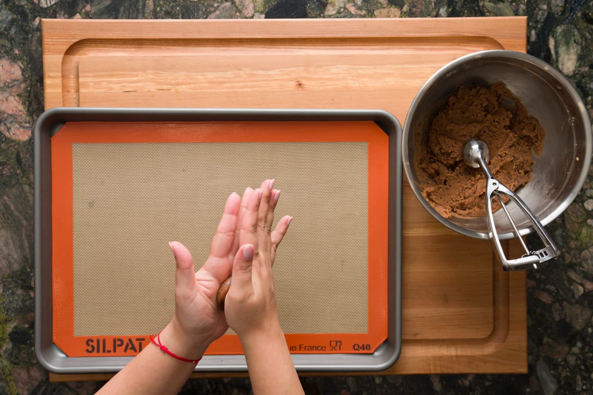 Flattening tiramisu cookie dough in between two hands.