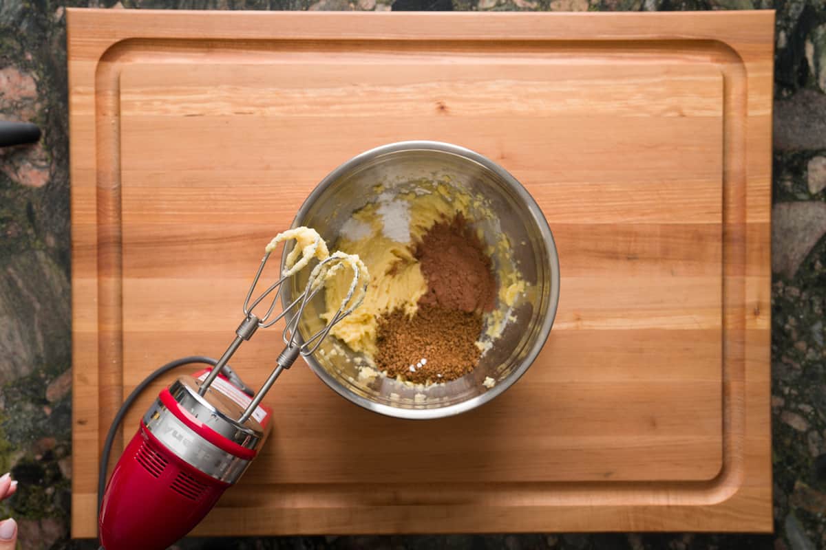 Mixing together the ingredients for mini tiramisu cookies using a handheld mixer.