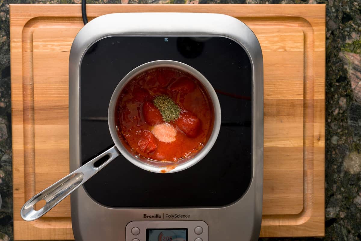 Ingredients for pizza sauce on a pot on a burner.