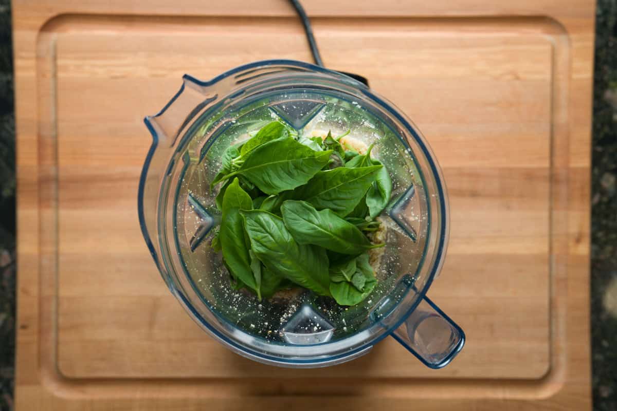 Fresh basil on inside a blender to make easy lemon basil pesto.
