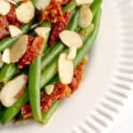 Zoomed shot of Italian green beans with sun-dried tomatoes and sliced almonds.