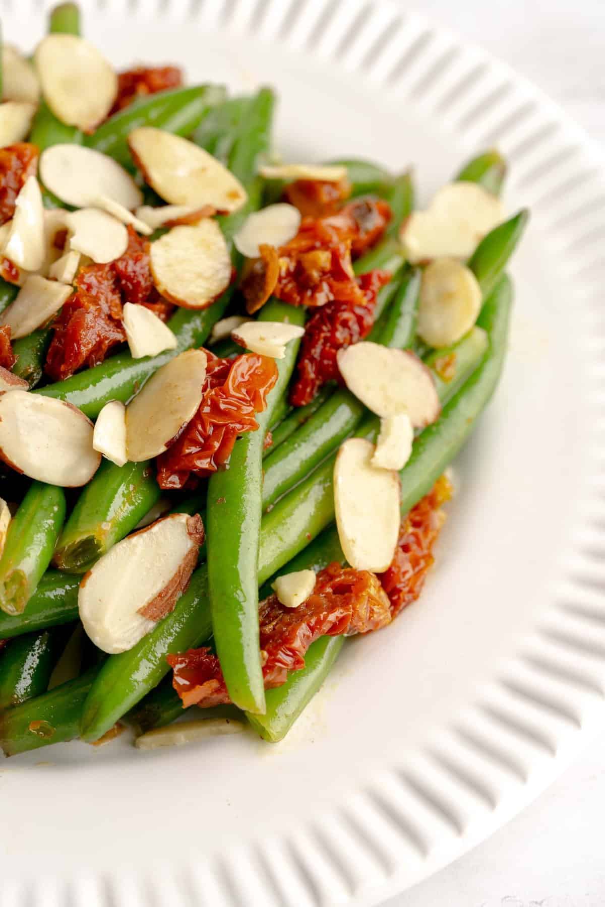 Close-up shot of Italian green beans with sun-dried tomatoes and sliced almonds.