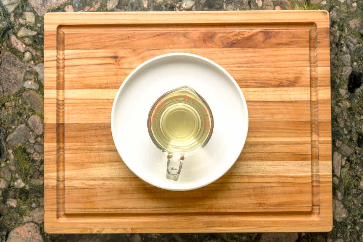 Overhead shot of strained basil simple syrup in measuring cup.