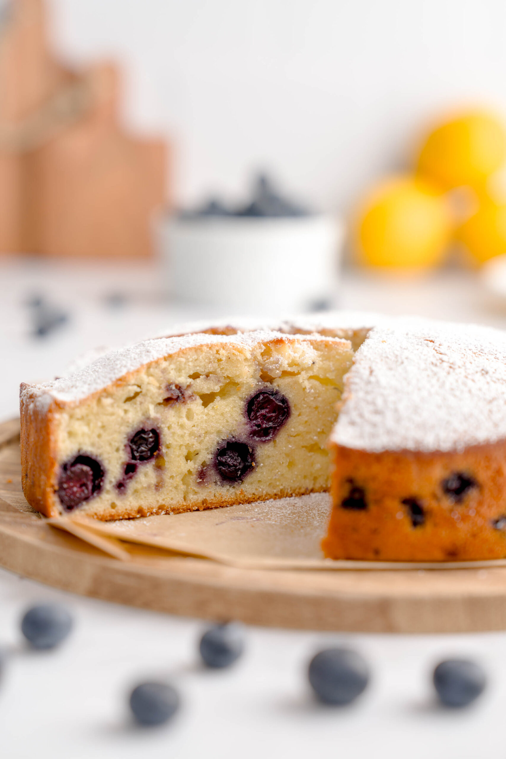 Cut slice of lemon olive oil cake with blueberries.