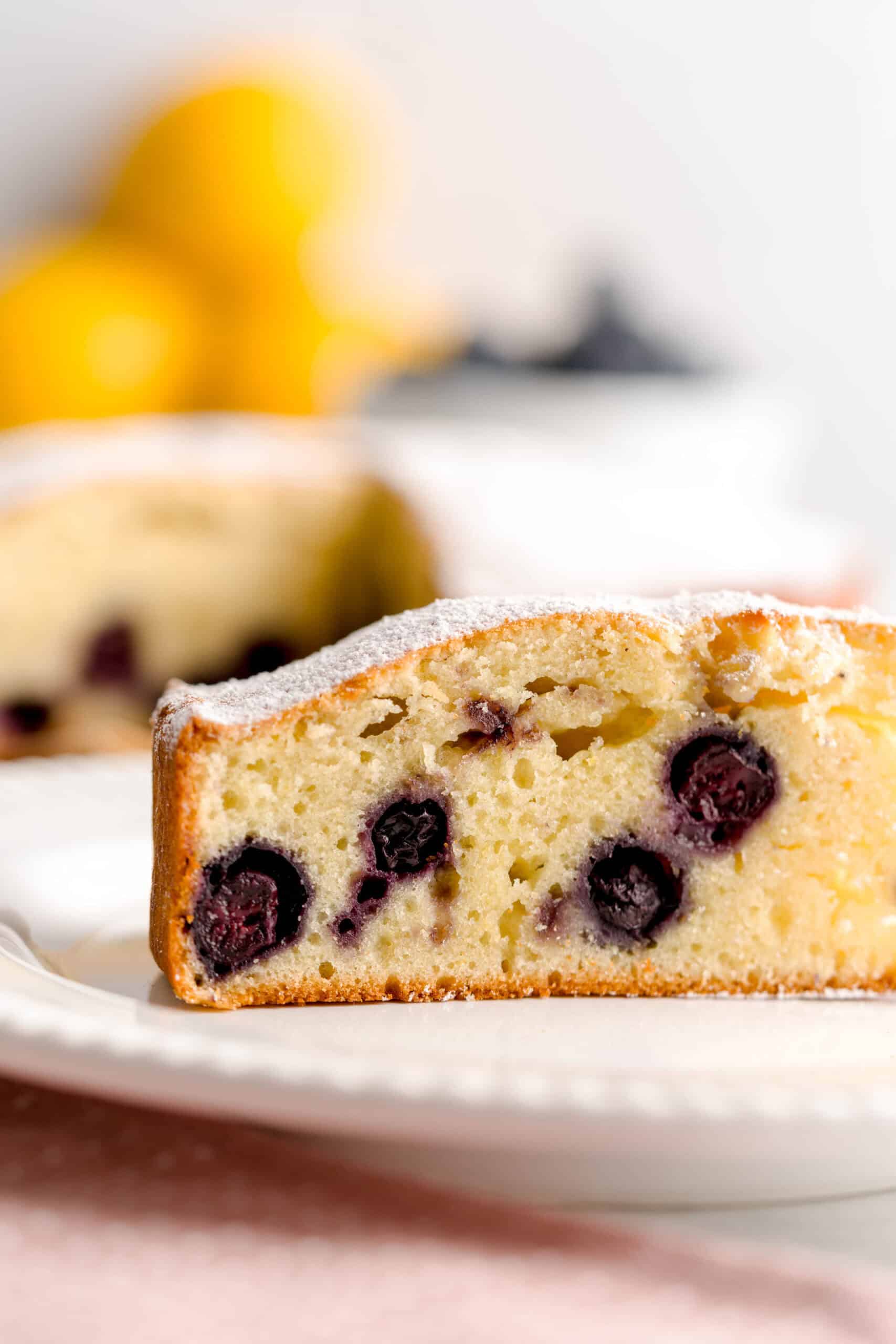 Plated Italian olive oil cake with lemons and blueberries.
