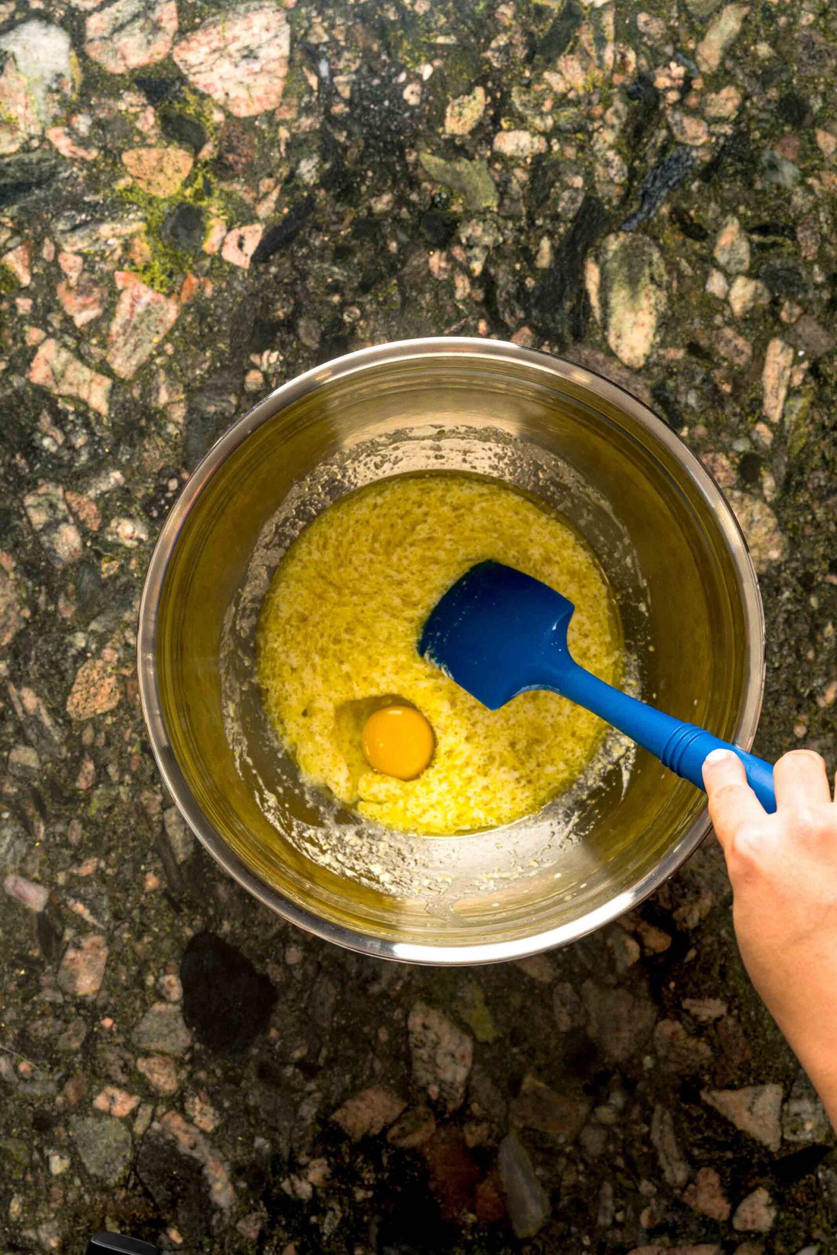 Whisking batter in bowl for homemade lemon blueberry cake.