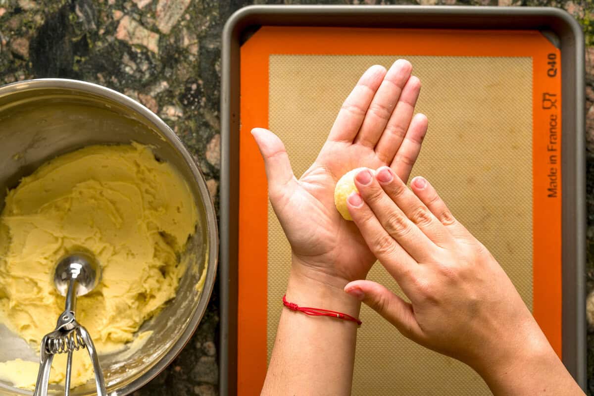 Flattening easy Italian ricotta cookie dough balls.