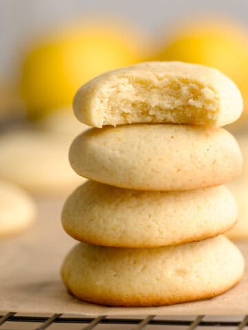 Soft lemon ricotta cookies stacked on top of one another.