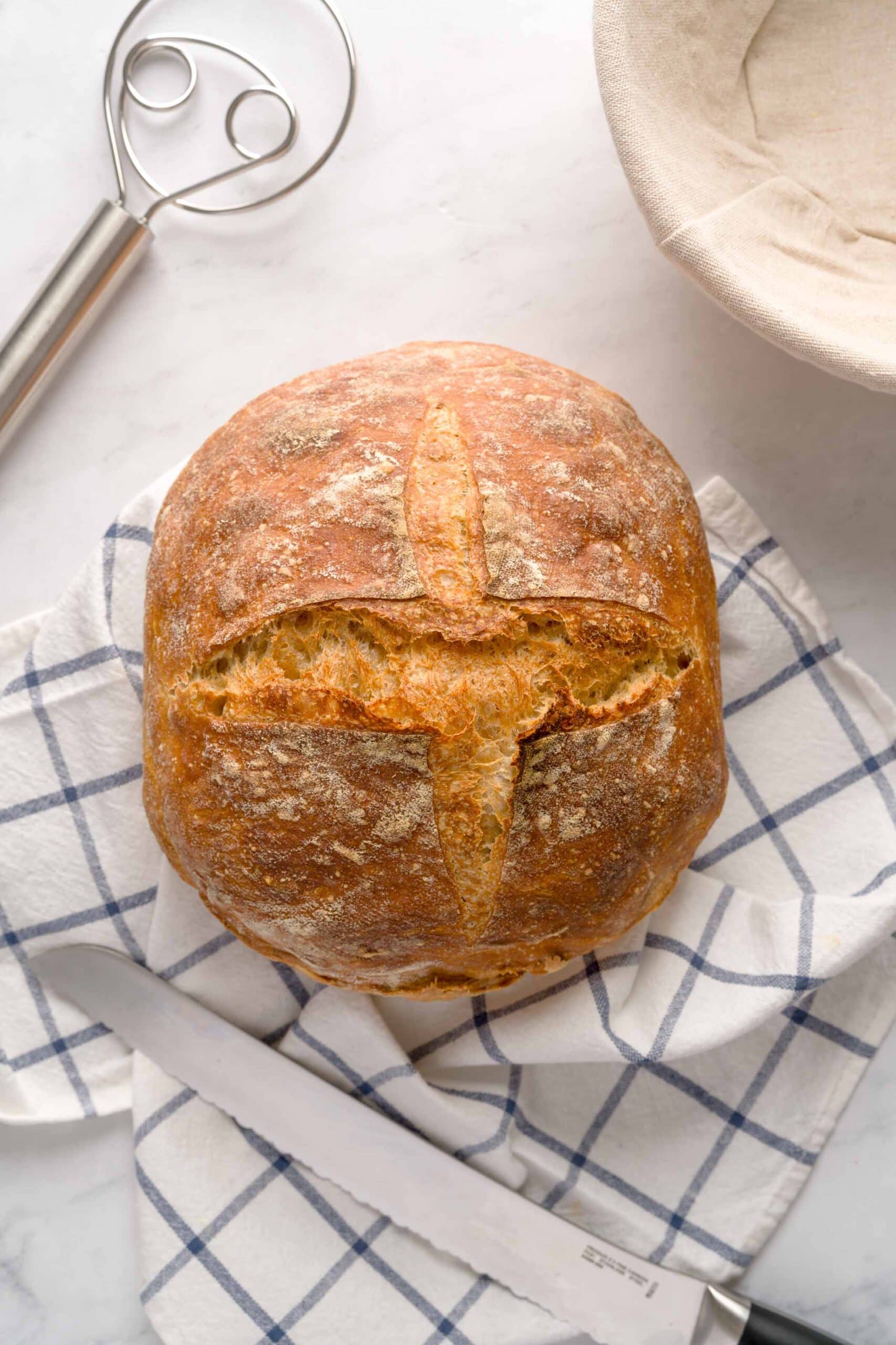 A loaf of homemade Italian bread on a tea towel.
