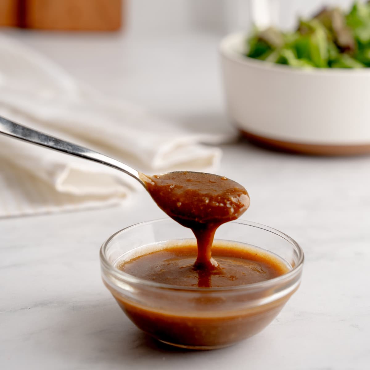 spoon  with dressing in a clear bowl