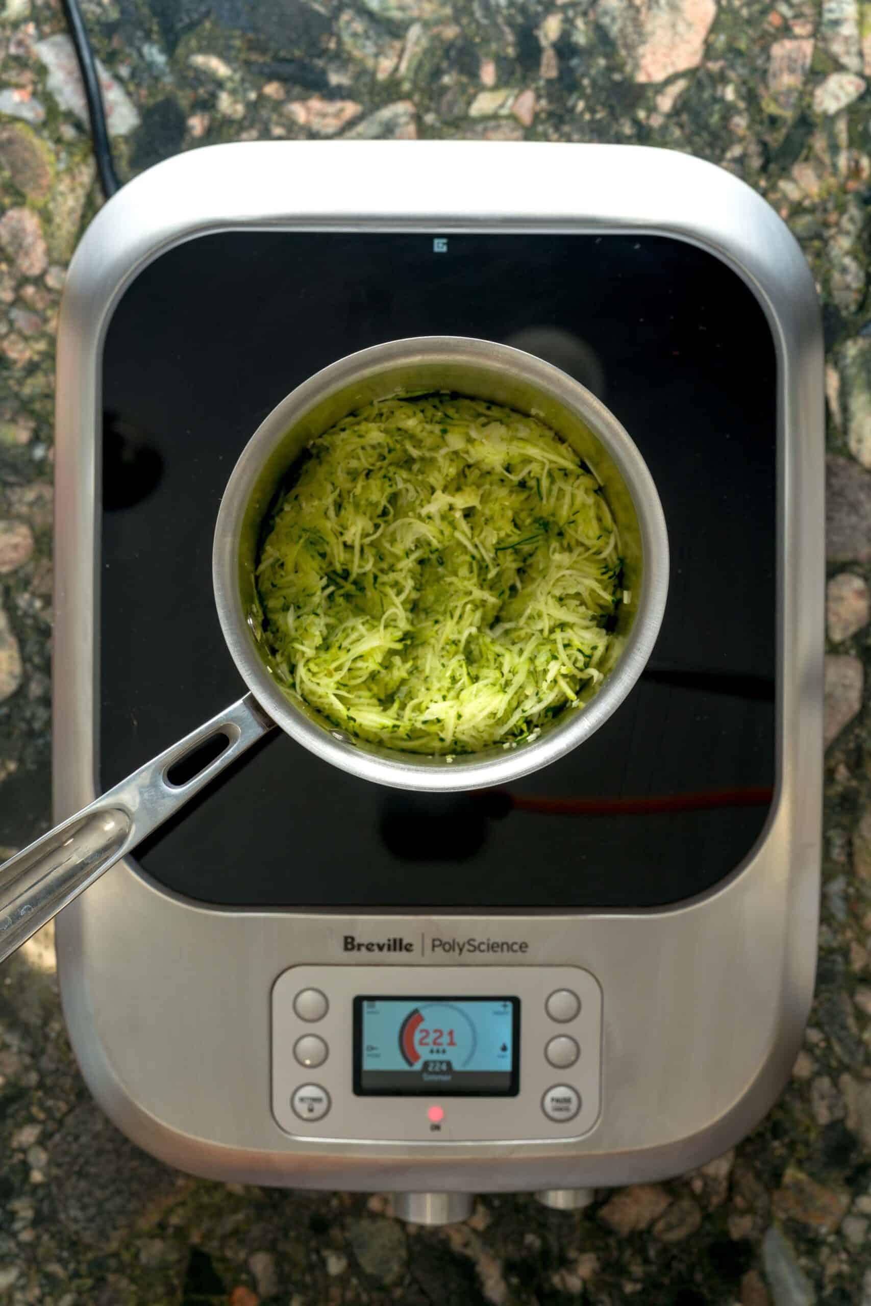 Cooking down zucchini in a pot for creamy pastina.