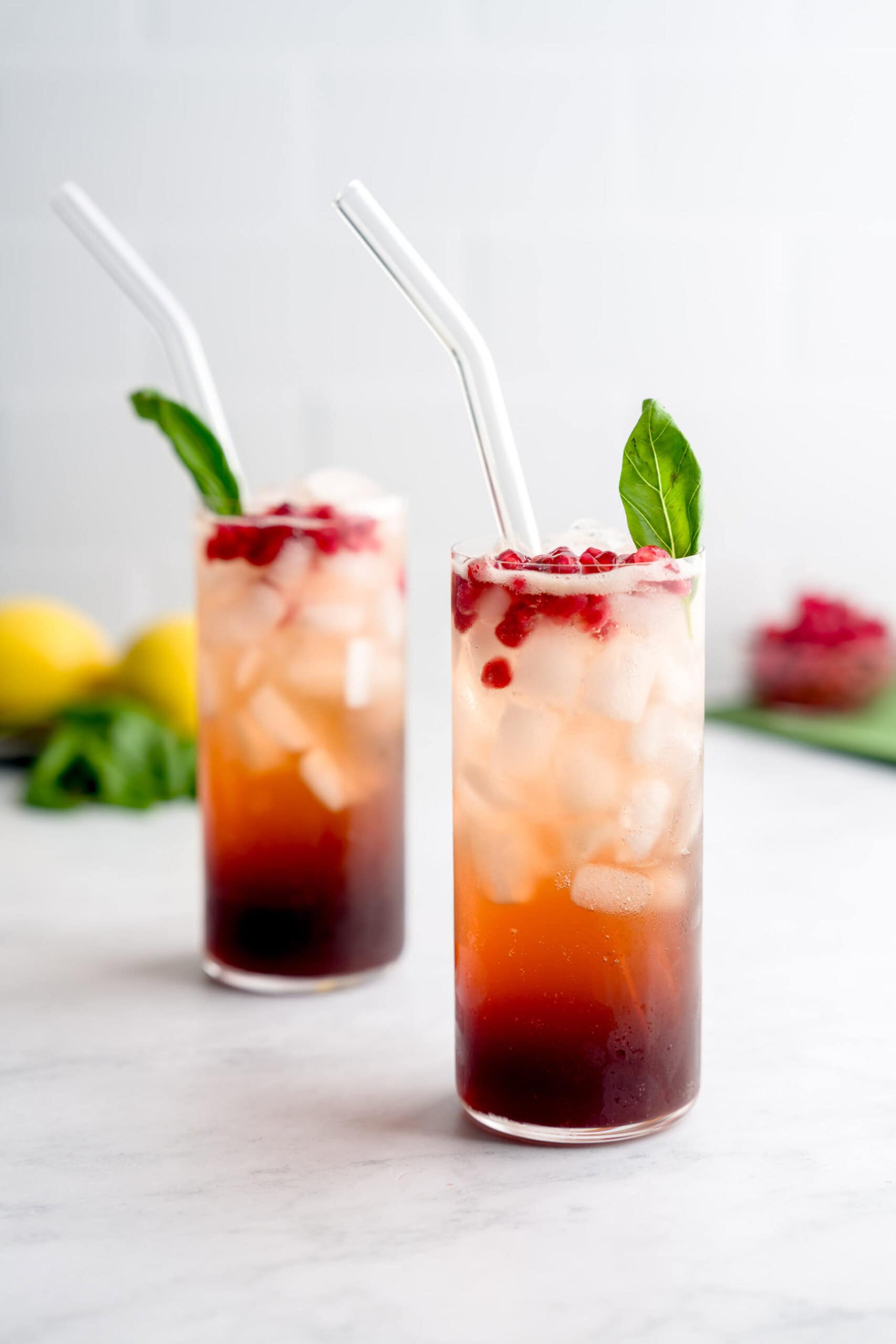 Two glasses of refreshing, Italian-inspired pomegranate basil mocktails for fall festivities.