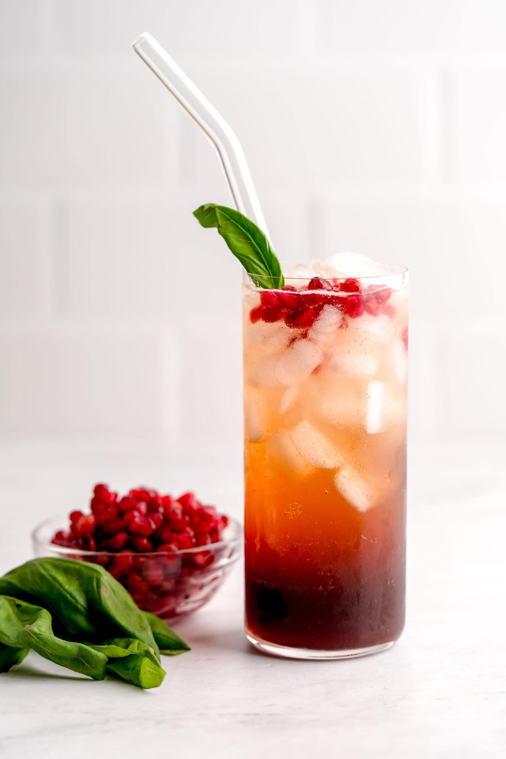 Italian-inspired basil pomegranate cocktail with fresh pomegranate seeds.