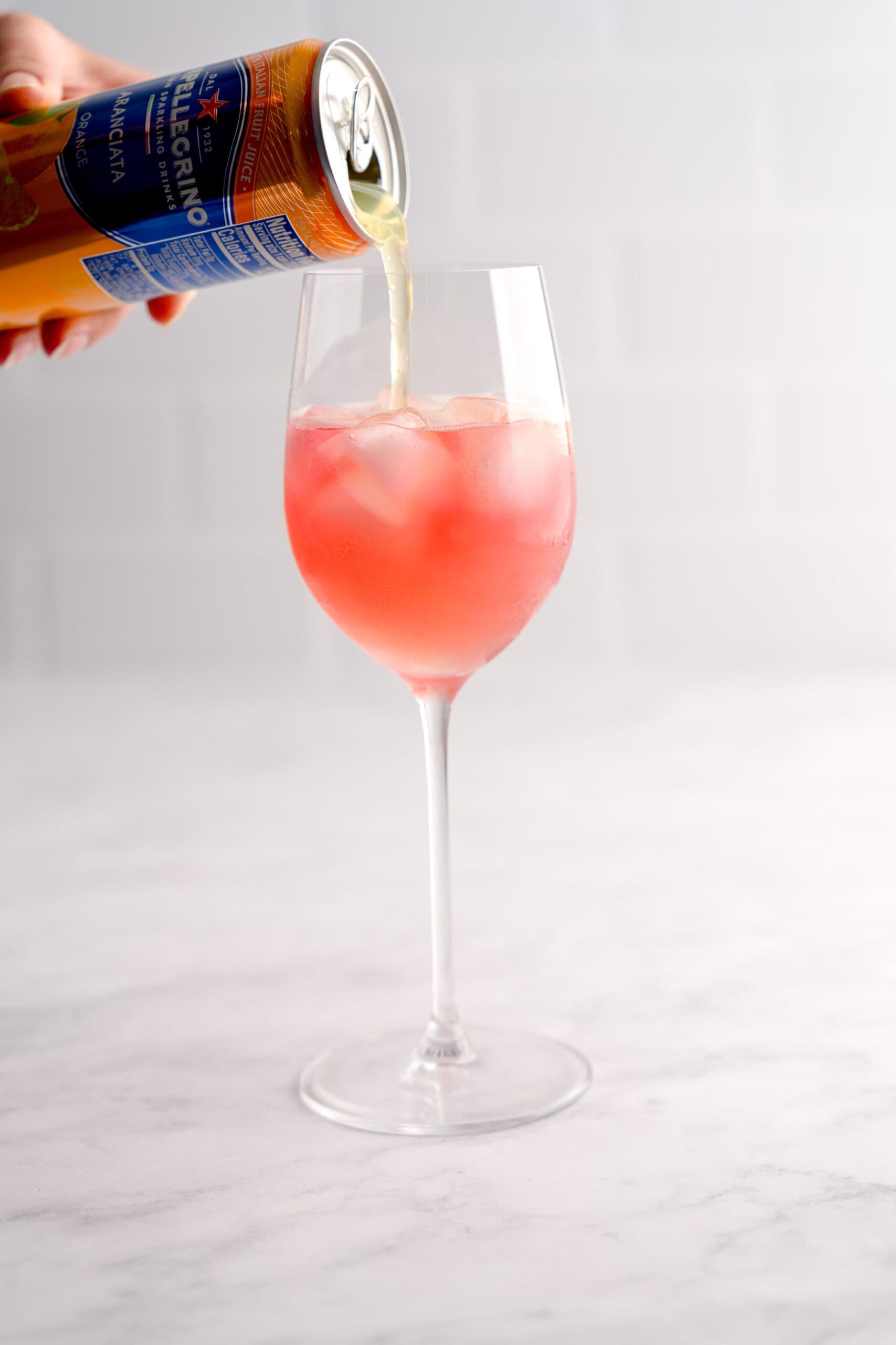 Adding aranciata orange soda to an Italian cranberry spritz for the fall season.