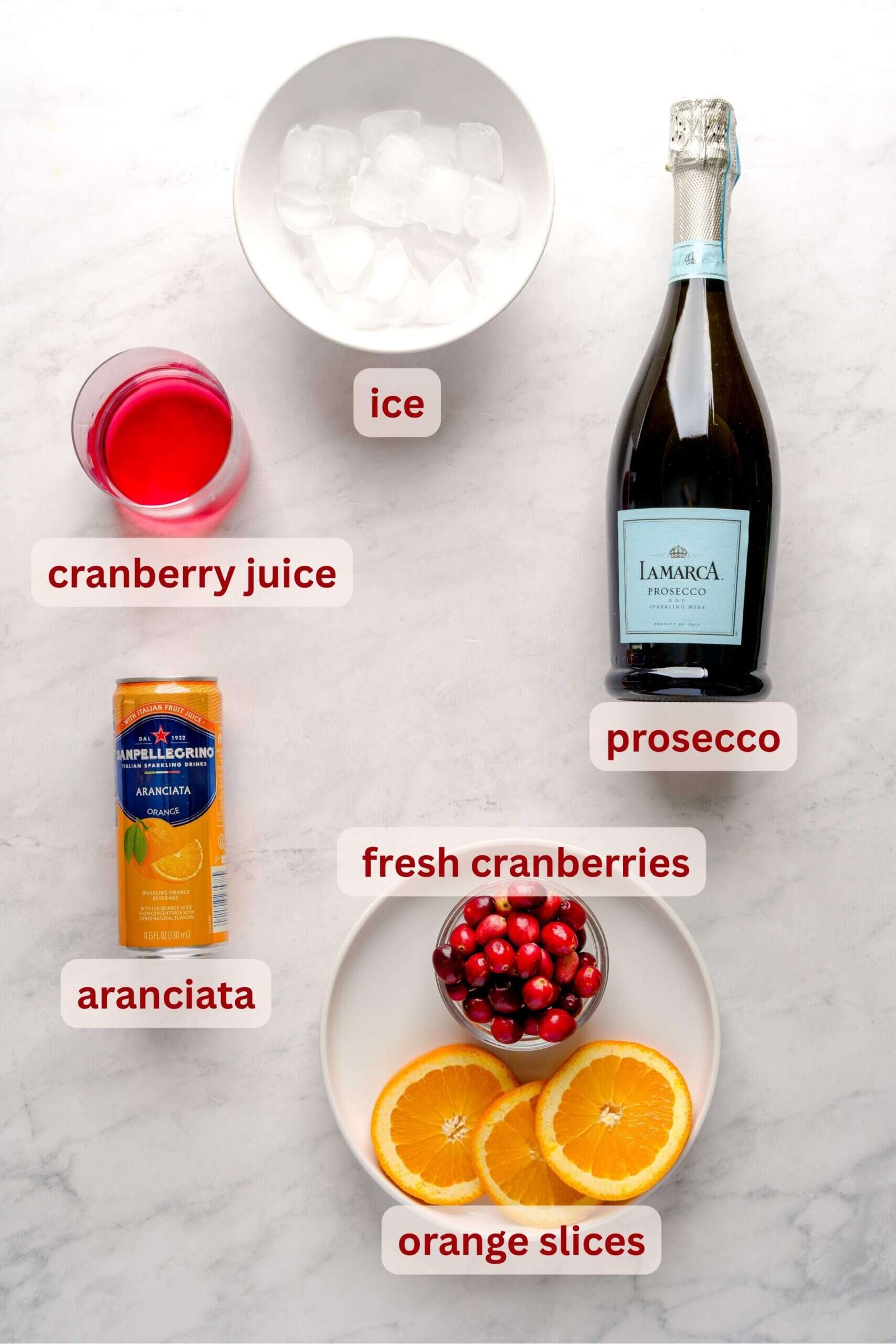 Ingredients to make an Italian-inspired drink for fall, cranberry aranciata spritz.