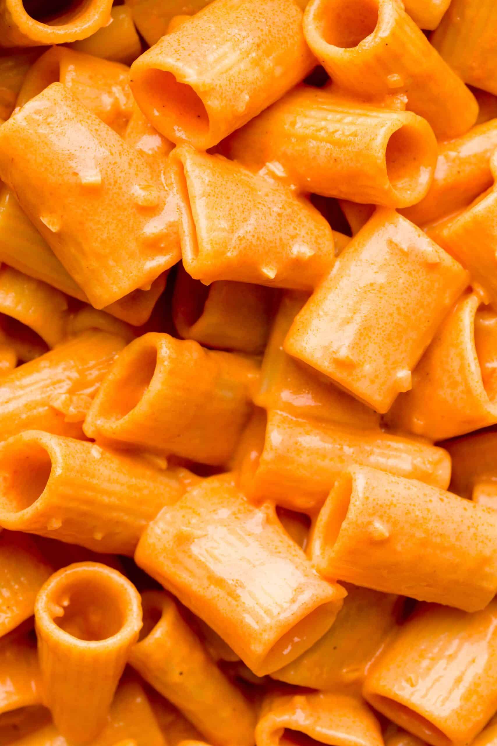 Close up shot of creamy vodka sauce on top of rigatoni pasta.
