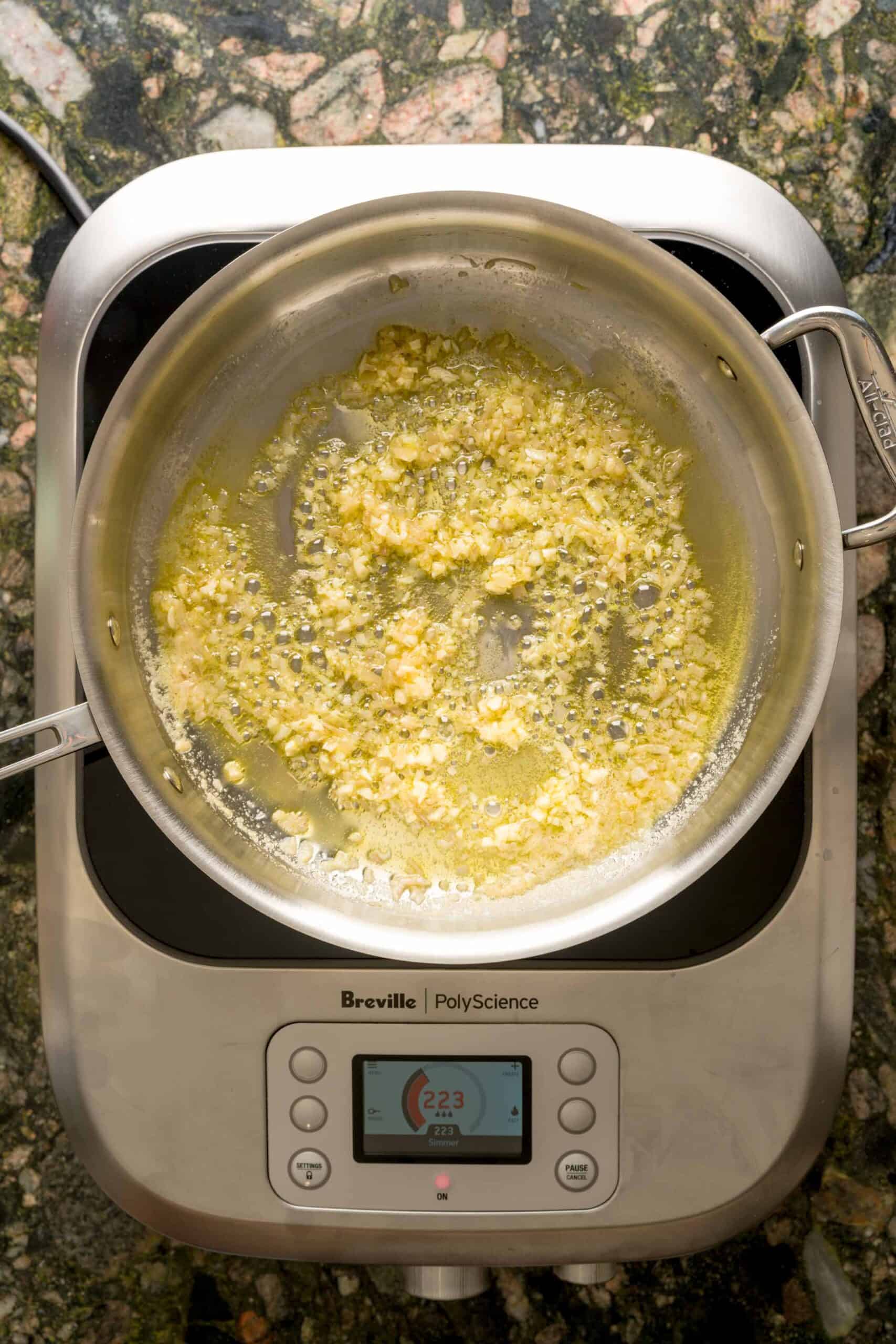 A pan sautéing shallots and garlic in butter and olive oil for creamy vodka pasta.