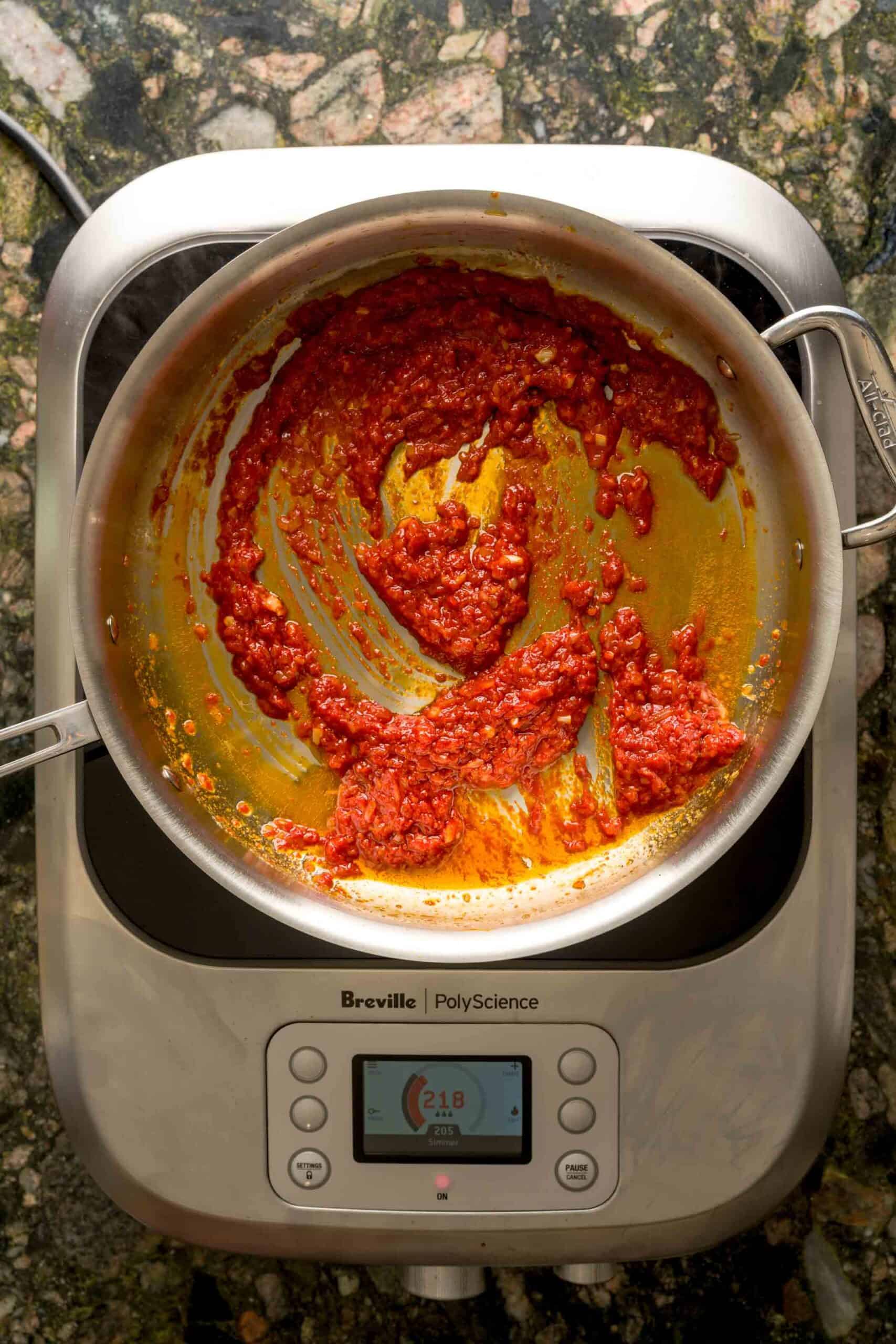 Blooming tomato paste in a large pot to make vodka pasta sauce.