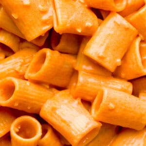 Close up shot of creamy vodka sauce on top of rigatoni pasta.