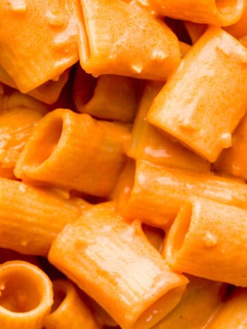 Close up shot of creamy vodka sauce on top of rigatoni pasta.