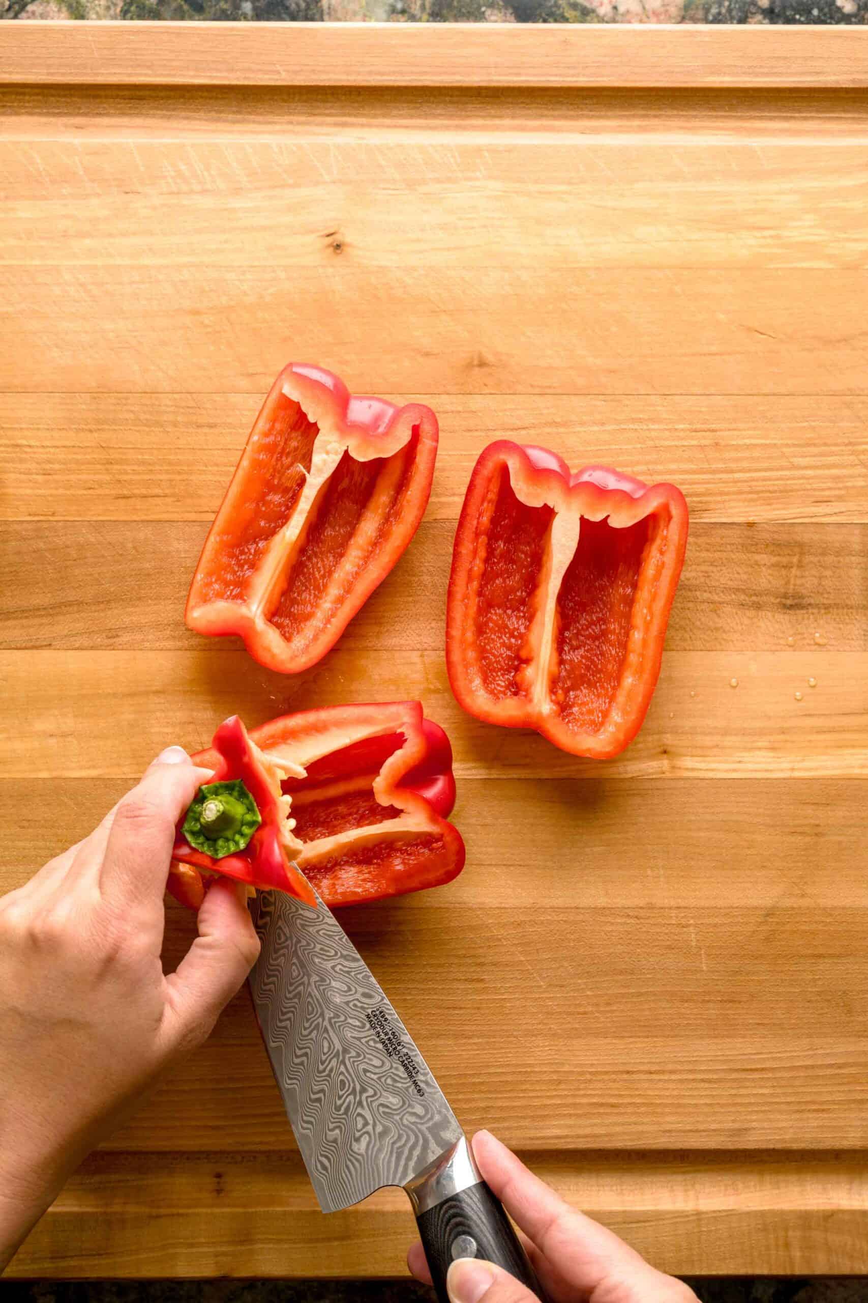 Cutting red peppers for easy oven-roasted Italian roasted pepper recipe.