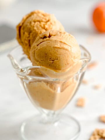 Pumpkin spice pumpkin gelato in a glass ice cream cup.
